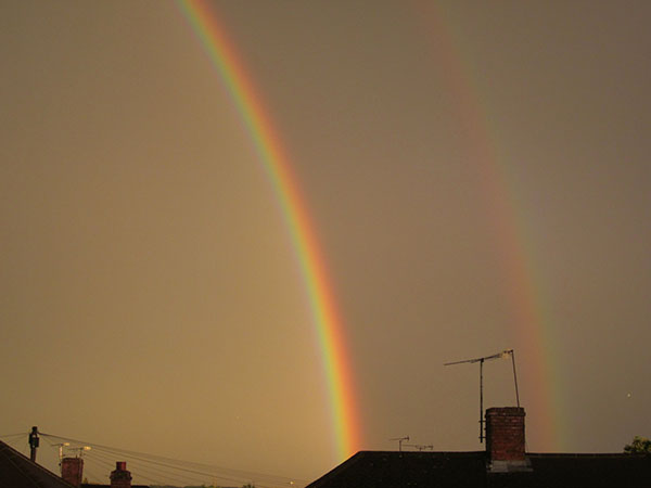 A rainbow illuminates the sky